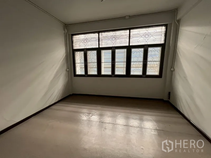 Shophouse for rent in Phra Khanong, Bangkok - Room featuring decorative window grilles allowing natural light.