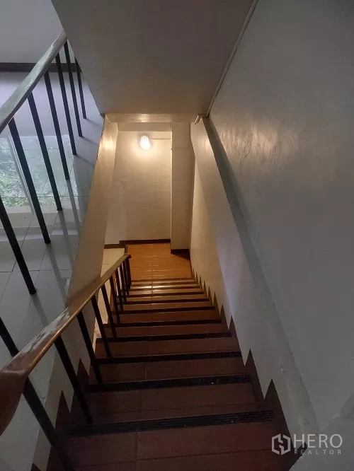 Shophouse for rent in Bang Rak, Bangkok - View down the staircase showing wooden treads and handrail inside the shophouse.