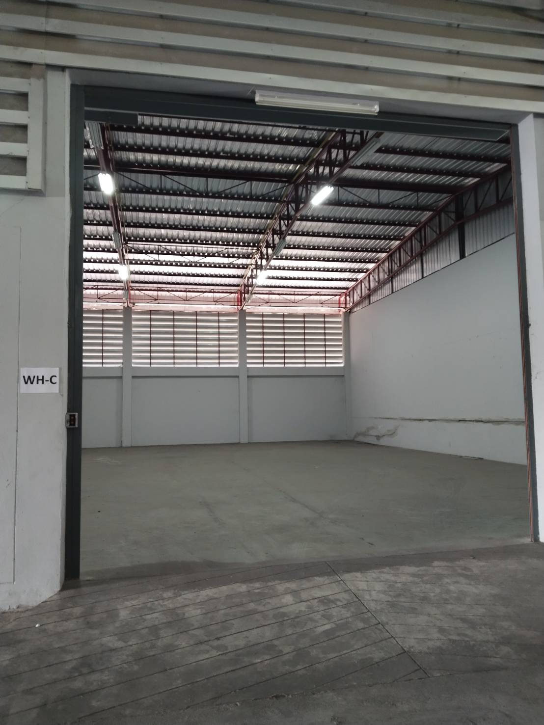 Warehouse for rent in Lat Krabang, Bangkok - Roller shutter entrance with ramp leading into warehouse bay marked WH‑C.