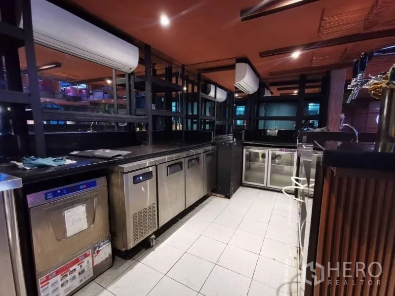 Retail Space for rent - Back bar service area with refrigerators, dishwashers, and black countertops.