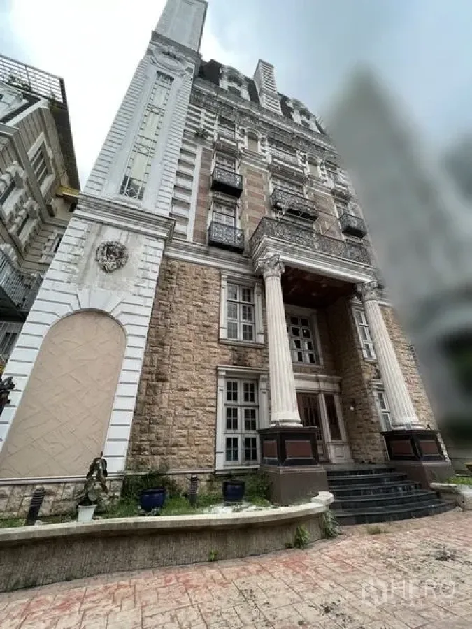 Home Office for rent in Huai Khwang, Bangkok - Multi-storey classical facade with stone cladding and prominent front columns.