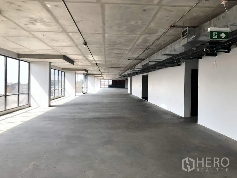 Office Space for rent in Suan Luang, Bangkok - Long rectangular office floorplate with large side windows, concrete floor, and ceiling-mounted services.
