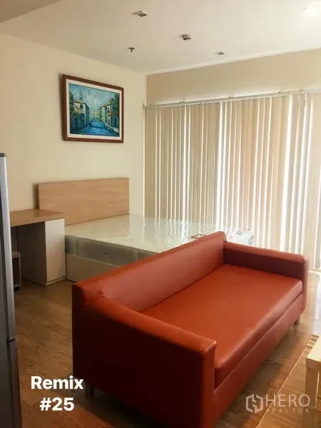 Condominium for rent in Khlong Toei, Bangkok - Studio living area with orange sofa, bed base, floor-to-ceiling vertical blinds and wall art in a bright condo.