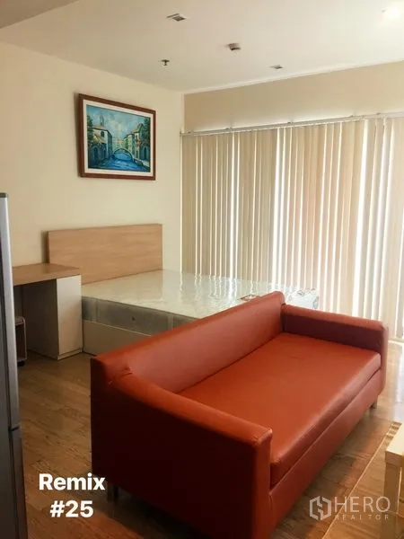 Condominium for rent in Khlong Toei, Bangkok - Studio living area with orange sofa, bed base, floor-to-ceiling vertical blinds and wall art in a bright condo.