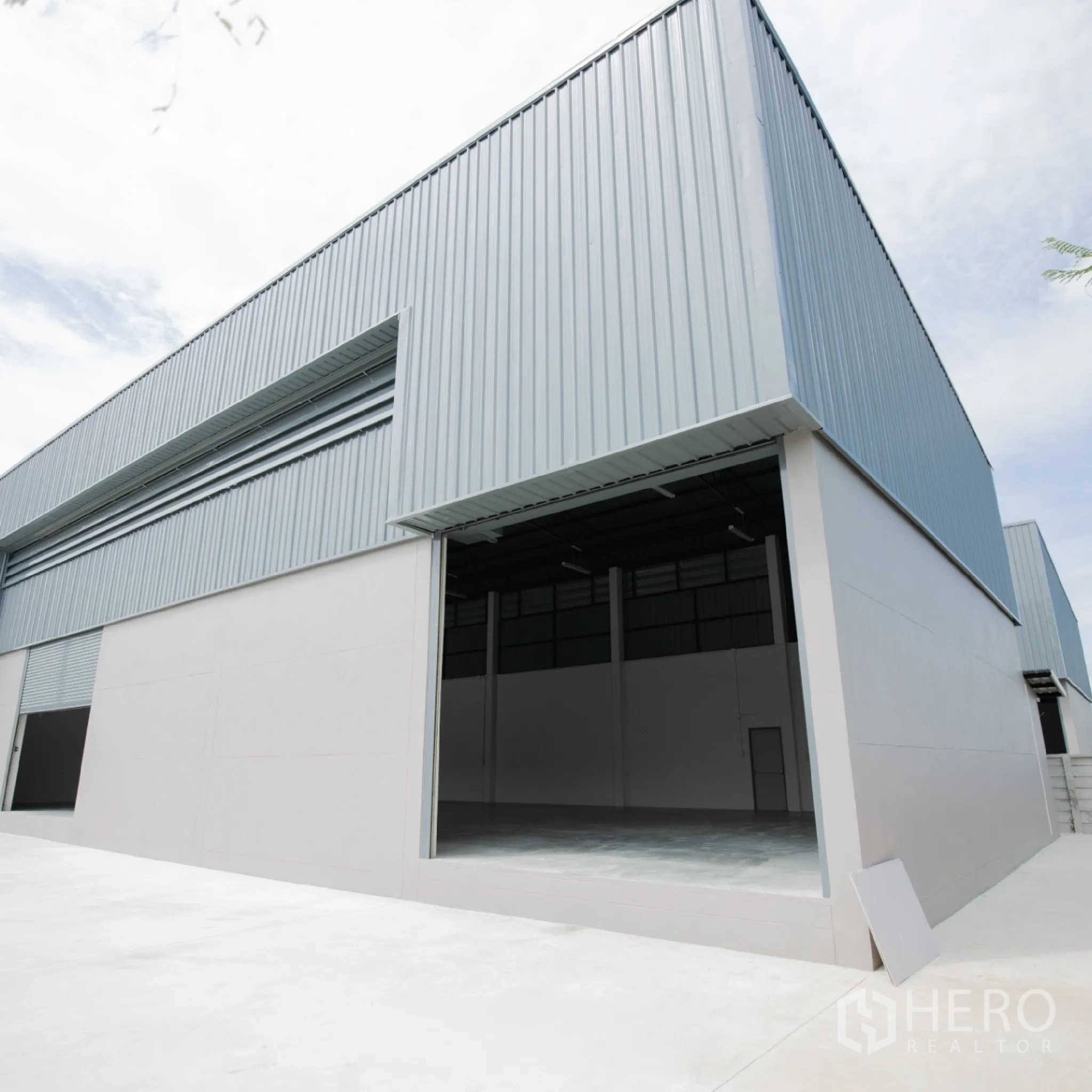 Factory for rent or sale in Bang Len, Nakhon Pathom - Steel-clad warehouse exterior with a large open loading bay and concrete apron.