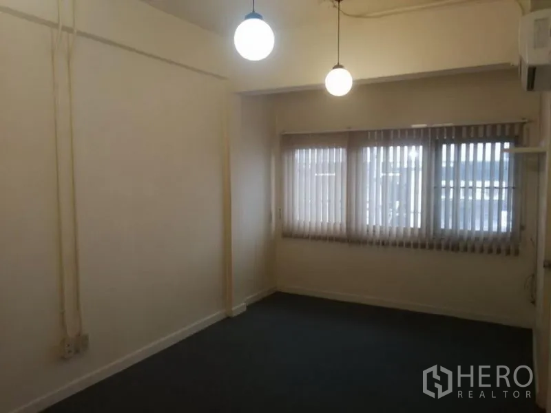 Townhouse for rent in Khlong Toei, Bangkok - Bright room featuring large windows, vertical blinds and hanging lights