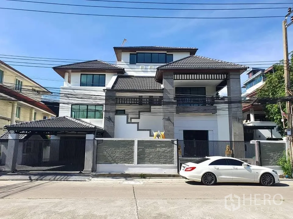 Home Office for rent in Wang Thonglang, Bangkok - Front façade of a large gated home office with driveway and high perimeter wall.