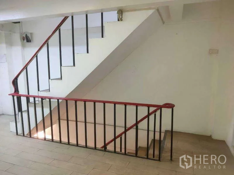 Shophouse for sale in Phra Khanong, Bangkok - Side view of the staircase with a red handrail and open landing.