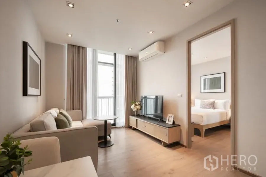 Condominium for rent - Modern living room with sofa, TV stand and balcony doors in a city condo.