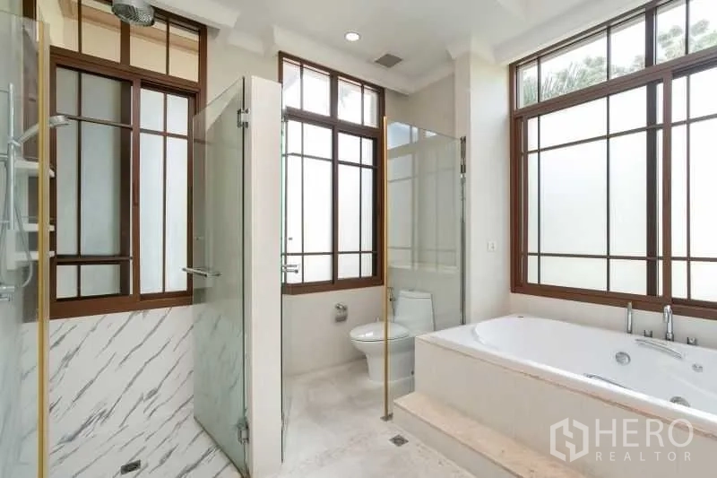 Detached House for rent in Watthana, Bangkok - Spa-style bathroom with glass shower, soaking bathtub and large windows.