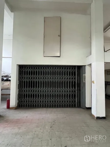 Shophouse for rent in Khlong Toei, Bangkok - Freight elevator with scissor gate inside the shophouse for efficient vertical goods movement.