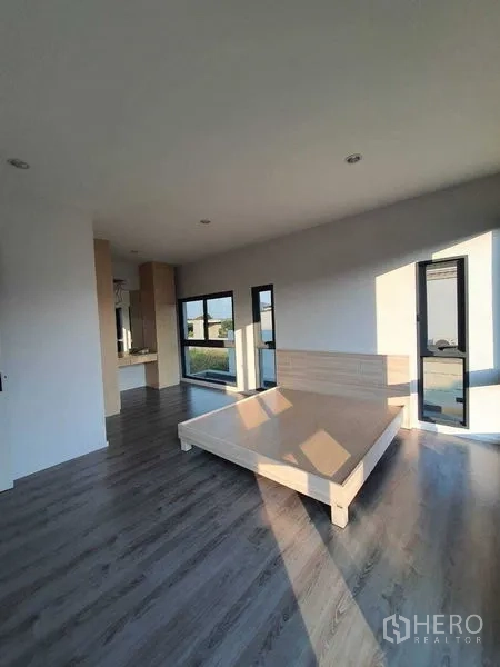 Detached House for sale in Prawet, Bangkok - Large bedroom with platform bed base and neighborhood views from windows.