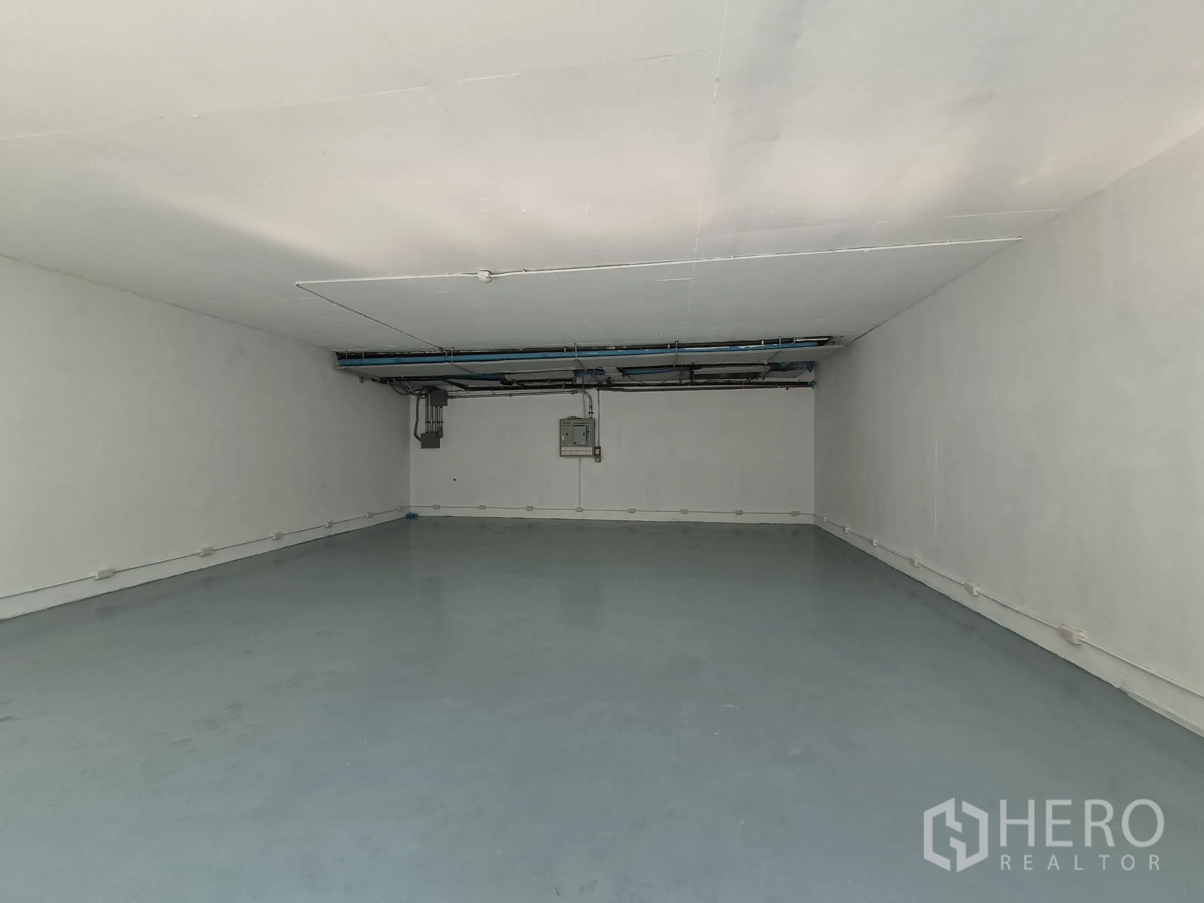 Retail Space for rent in Watthana, Bangkok - Deep rectangular shop space with smooth grey floor, white walls, and perimeter electrical outlets.