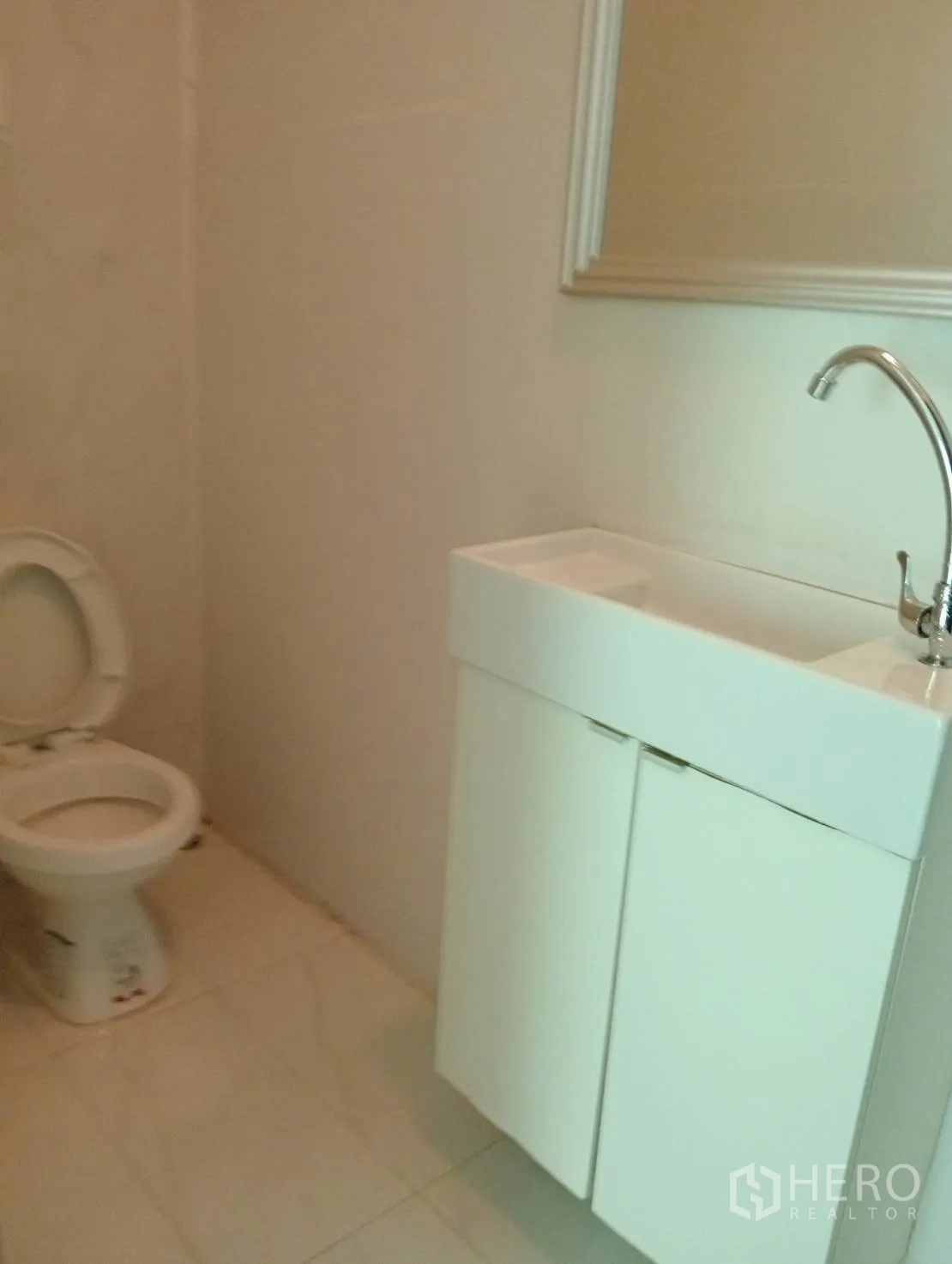 Home Office for rent in Khlong Toei, Bangkok - Guest bathroom with vanity cabinet, mirror and toilet.