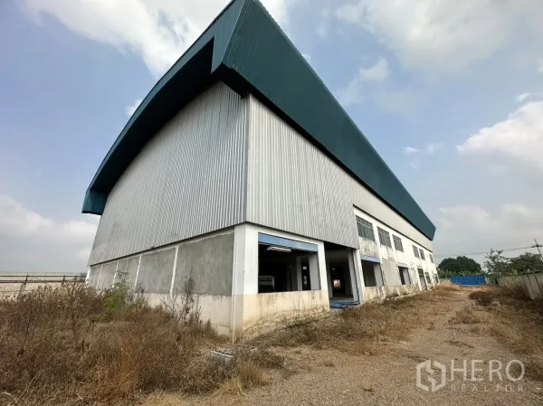 Factory for rent in Pak Kret, Nonthaburi - Long side elevation with rows of windows and loading openings along the factory.