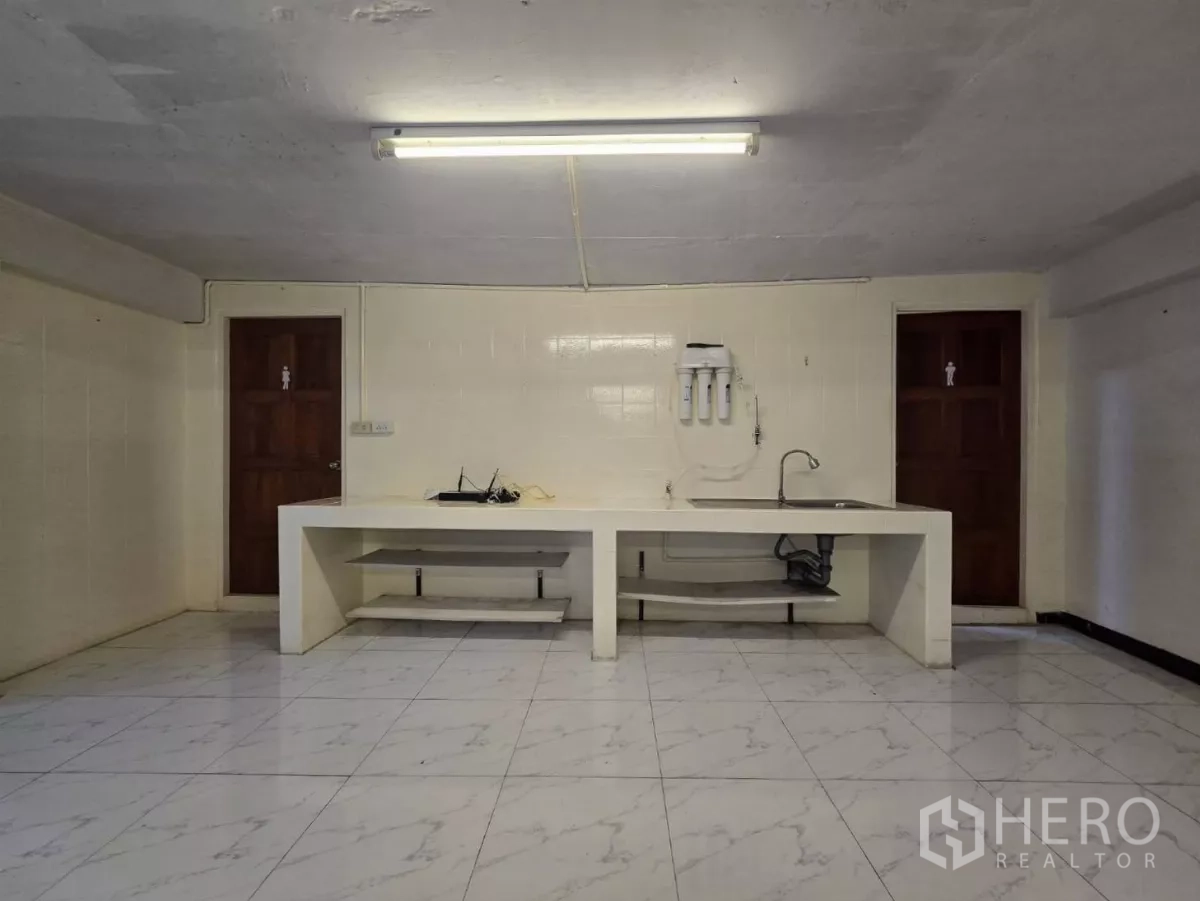 Warehouse for rent in Chatuchak, Bangkok - Pantry with sink and separate male and female restroom doors.