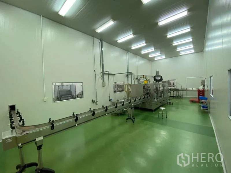 Warehouse for rent in Bueng Kum, Bangkok - Clean room production area with stainless conveyor line, machines and green epoxy floor beneath LED panels.