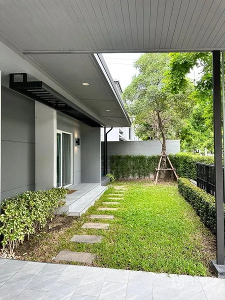 Detached House for sale in Prawet, Bangkok - Front garden with stepping stones, hedges and a covered porch.