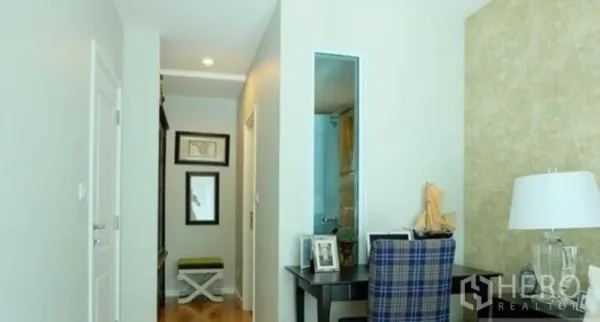 Condominium for rent in Khlong Toei, Bangkok - Hallway with desk nook, mirrors, and a door to the bathroom in a modern one-bedroom unit.