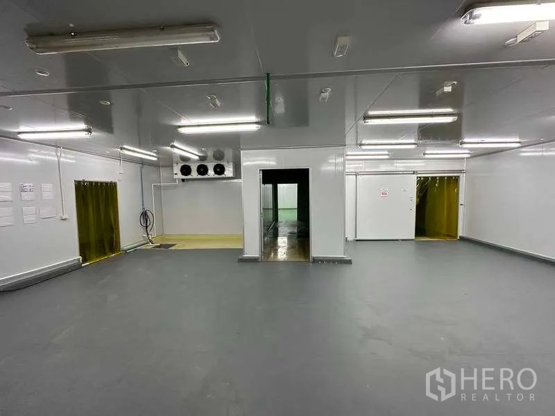 Warehouse for rent in Khlong Luang, Pathum Thani - Clean processing hall with sliding cold-room doors and multiple service entries.