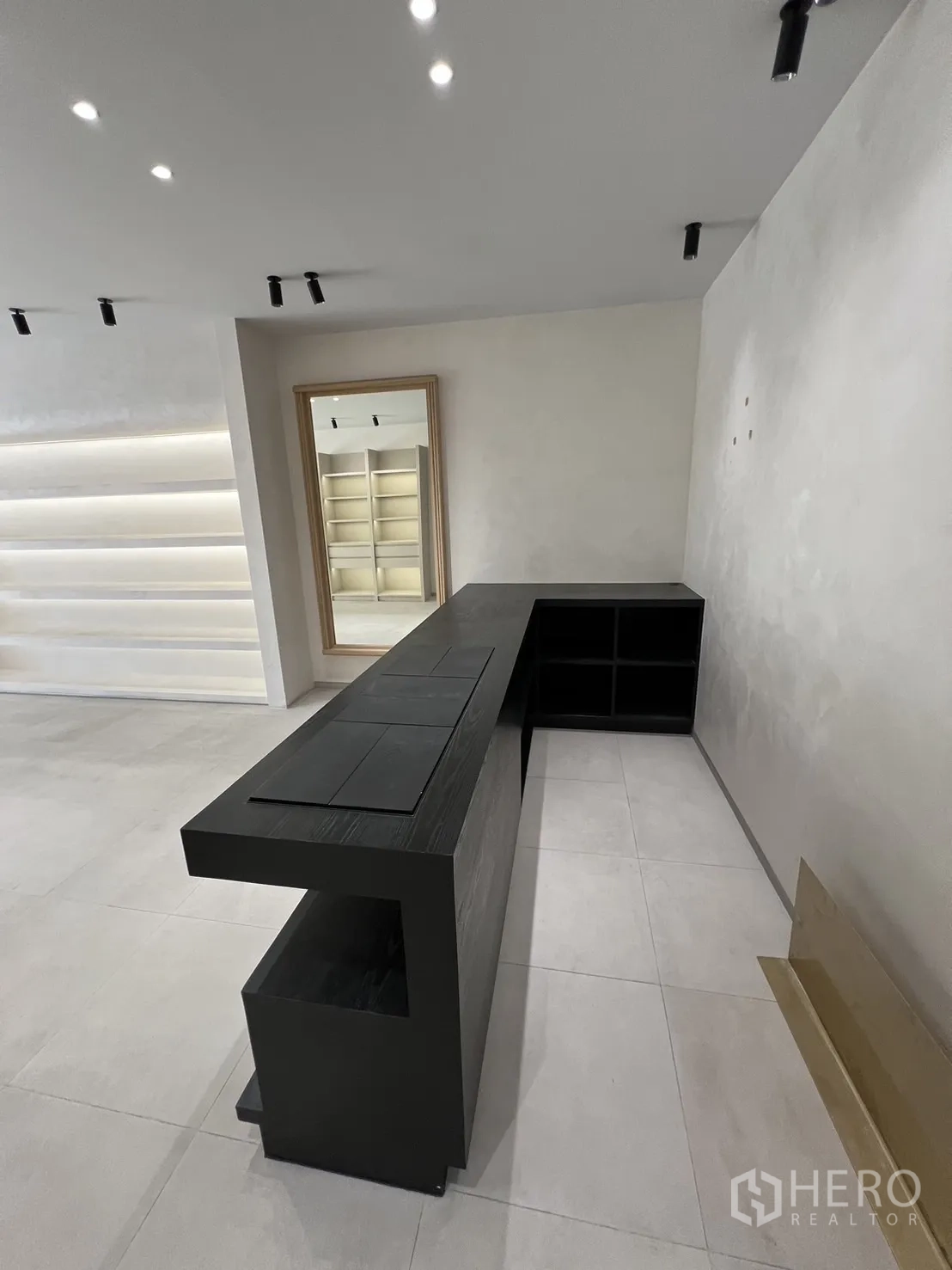Retail Space for rent in Bangkok - Modern black service counter facing a large mirror and built-in shelving