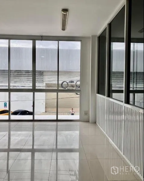 Warehouse for rent in Prawet, Bangkok - Second-floor office space with floor-to-ceiling windows overlooking parking.