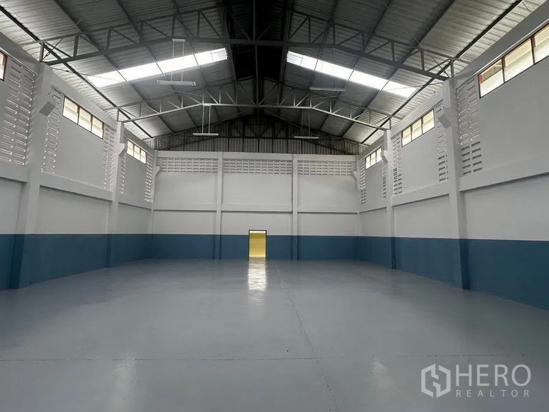 工厂 出租在Pathum Thani - 仓库后墙视角，带高侧窗通风与环氧地坪。