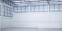 Factory for rent in Mueang Samut Sakhon, Samut Sakhon - Spacious warehouse interior with 8.1 m clear height, steel truss roof, louvered upper windows and smooth concrete floor.