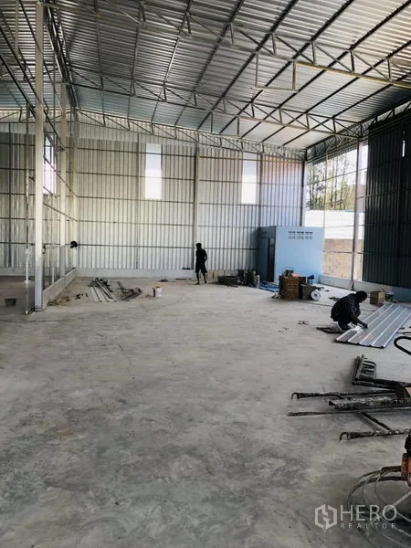 Warehouse for rent in Bang Kapi, Bangkok - Open-plan warehouse floor with metal siding, skylight panels and concrete surface.