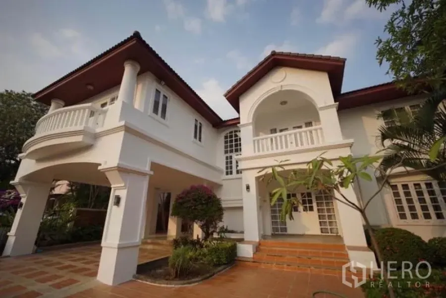 Detached House for rent in Bang Phli, Samut Prakan - Front exterior of a two-storey detached house with arched porch, balcony and landscaped garden.