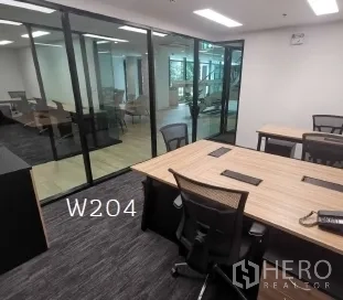 办公空间 出租在Khlong Toei, Bangkok - 紧凑型办公区，木质工位、网椅、地毯地面与玻璃隔断，位于曼谷空堤区。