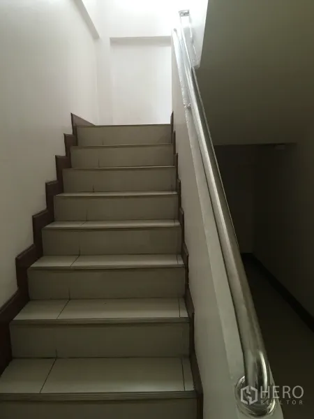 联排别墅 出租在Khlong Toei, Bangkok - 室内楼梯，瓷砖踏步与金属扶手通往二层