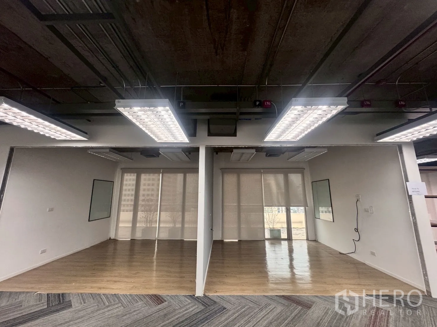 Office Space for rent in Watthana, Bangkok - Two glass-partitioned rooms featuring wood floors, roller blinds, and full-height windows.