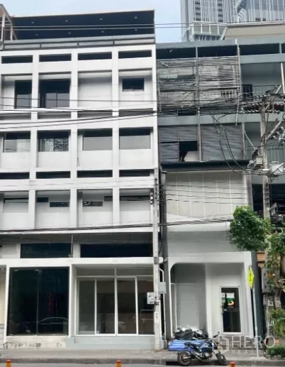 Shophouse for rent in Watthana, Bangkok - Modern five-storey shophouse facade on a main road with a glass storefront.