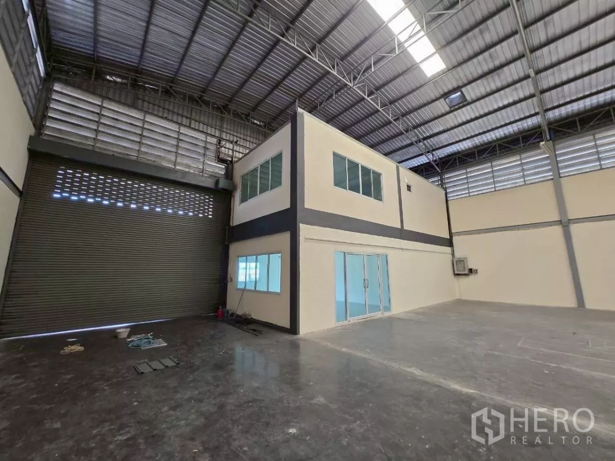 Factory for rent or sale in Mueang Samut Sakhon, Samut Sakhon - Warehouse corner featuring a two-storey internal office block, glass doors and an oversized roller door.