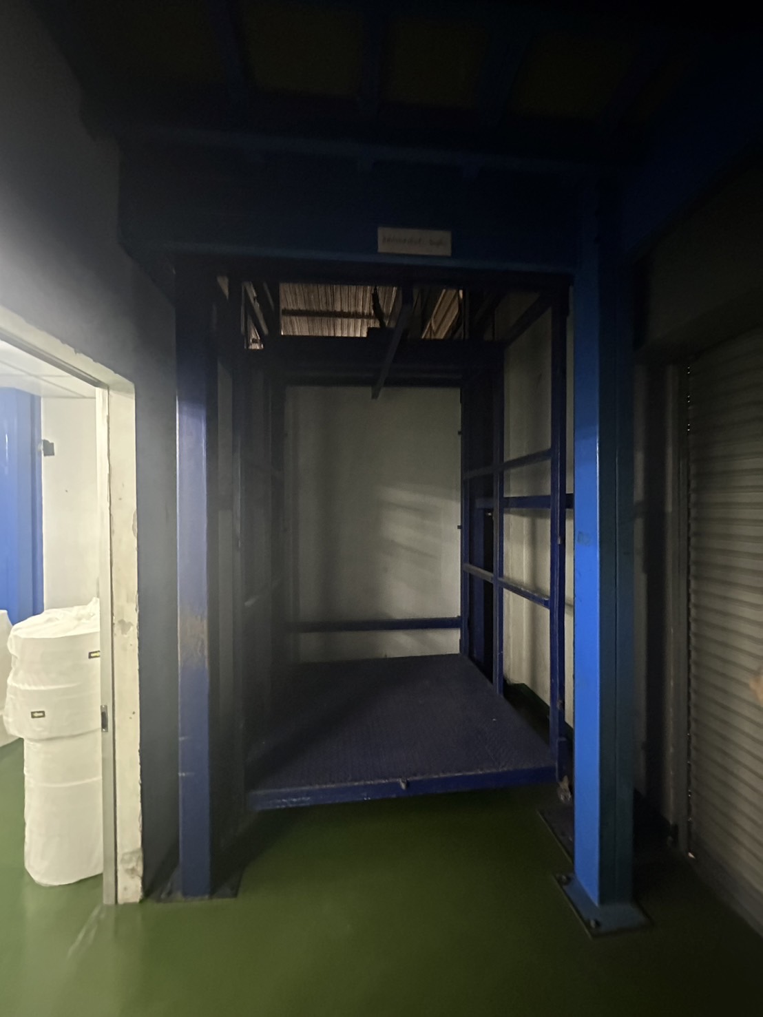Warehouse for rent or sale in Lam Luk Ka, Pathum Thani - Freight lift platform with blue steel frame for moving goods between floors.