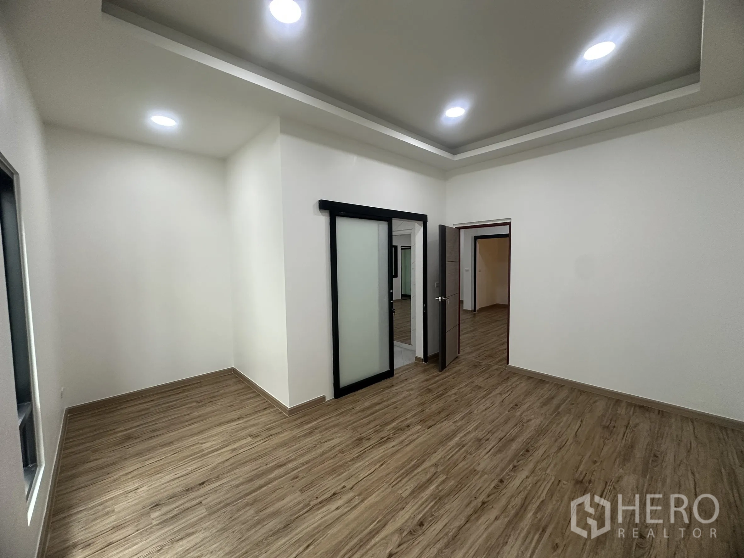 Warehouse for sale in Khlong Luang, Pathum Thani - Private office or bedroom with cove ceiling, sliding door and wood-look flooring.