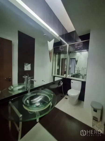 Shophouse for rent in Watthana, Bangkok - Bathroom with a glass bowl sink, large mirror wall, and toilet.