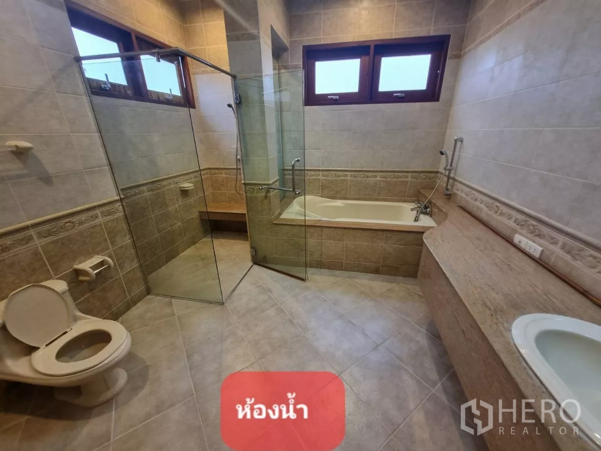 Home Office for rent or sale in Chatuchak, Bangkok - Spacious bathroom featuring a bathtub, glass-enclosed shower, and long vanity counter.