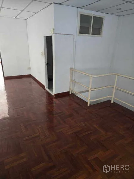Shophouse for rent in Watthana, Bangkok - Upper landing with handrail, parquet floor and access to restroom.