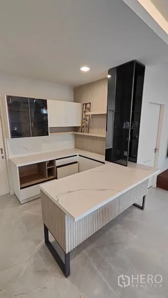 Detached House for rent in Prawet, Bangkok - Contemporary kitchen with marble-style island and built-in cabinetry.
