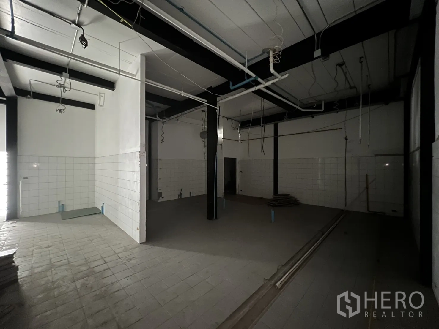 Retail Space for rent in Watthana, Bangkok - Empty storage room with high ceiling and tiled floor.