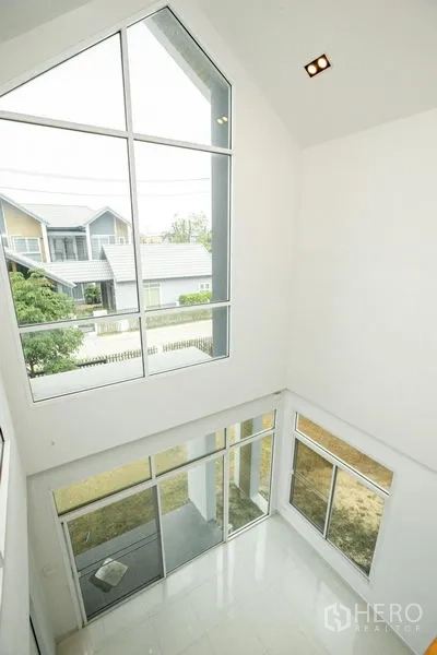 Detached House for rent or sale in Lam Luk Ka, Pathum Thani - View from the upper floor into the double-volume living room with tall gable window.