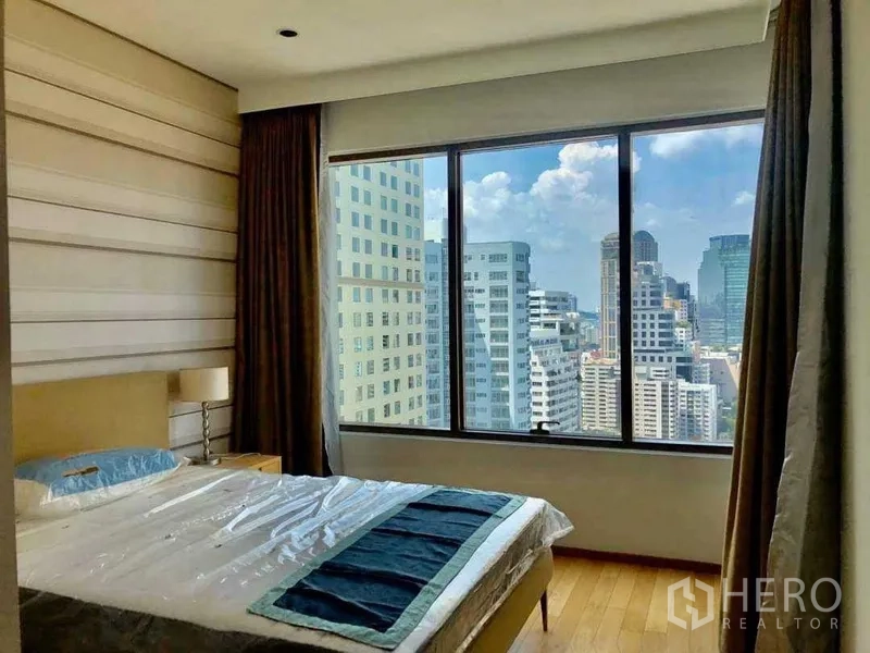 Condominium for sale in Khlong Toei, Bangkok - Second bedroom with a large window and high-rise city views.