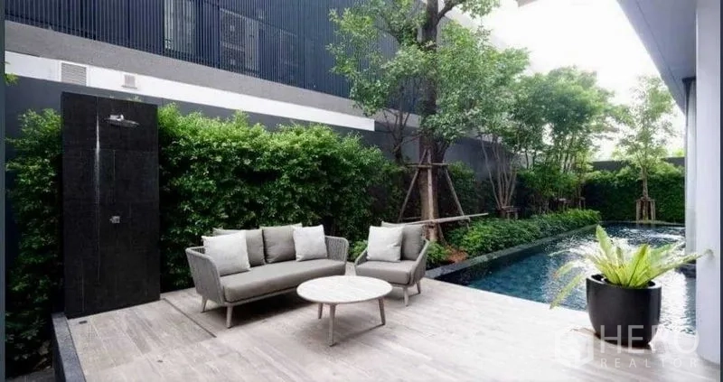 Detached House for sale in Huai Khwang, Bangkok - Poolside terrace with sofa seating, outdoor shower and dense hedging for privacy.