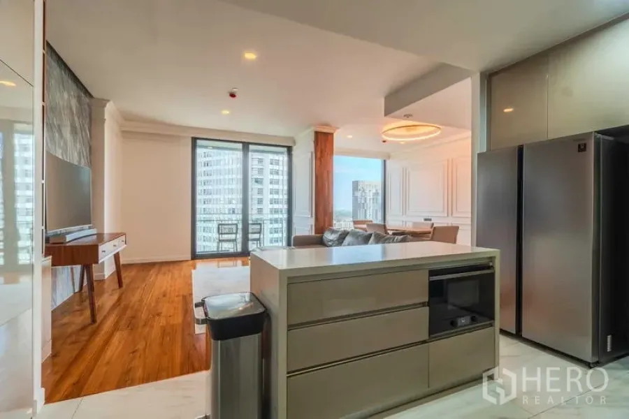 Condominium for rent or sale - Open-plan layout showing island kitchen, stainless fridge, and balcony beyond.