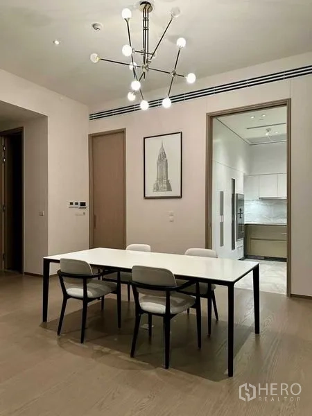 Condominium for rent or sale - Minimal dining room with modern chandelier and four-seat table beside the kitchen.