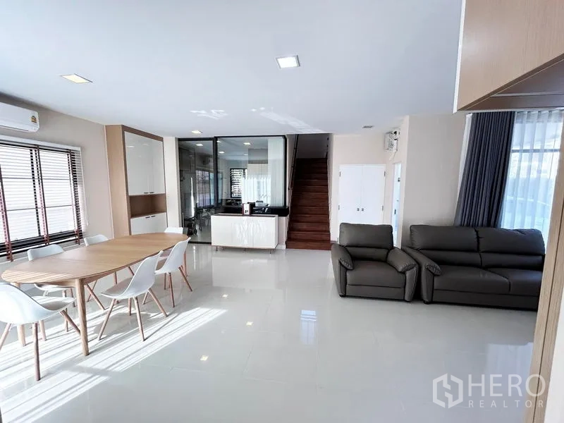 Detached House for rent or sale in Prawet, Bangkok - Open-plan living and dining area facing staircase and glass partition.