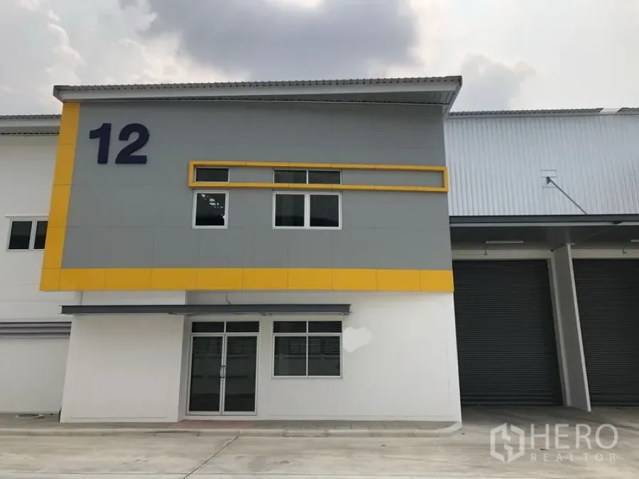 Factory for rent in Phra Nakhon Si Ayutthaya - Front facade of factory unit 12 with glass entry and grey‑yellow cladding beside loading shutters.