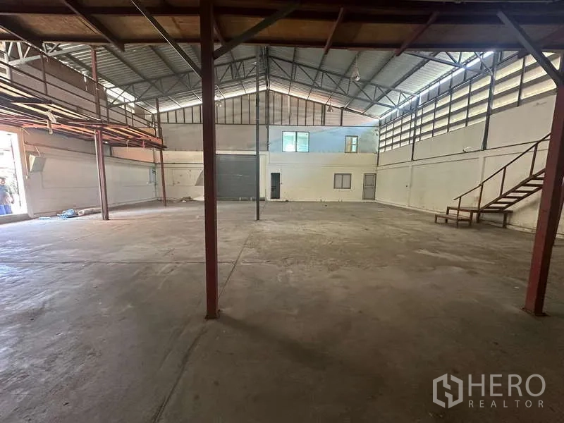 货栈 出租在Suan Luang, Bangkok - 宽阔仓储区，高屋顶与通风窗，靠近装卸口。
